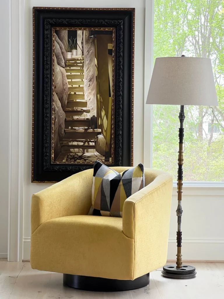 A yellow chair and lamp in front of a window.