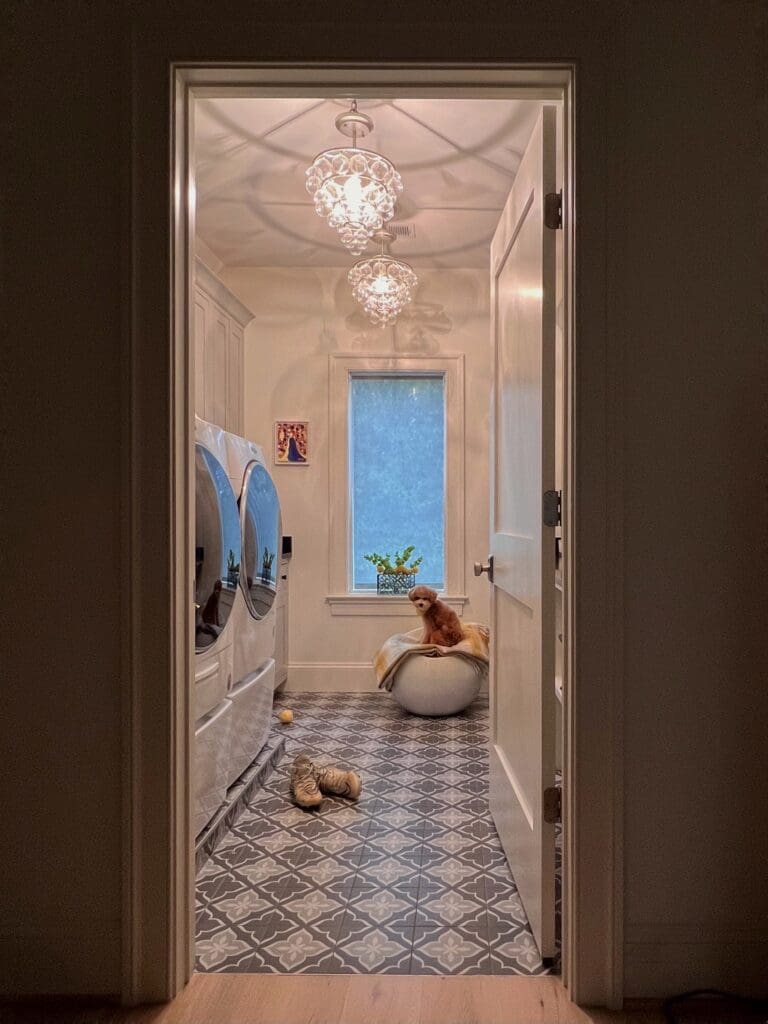 A cat sitting on the floor of a bathroom.