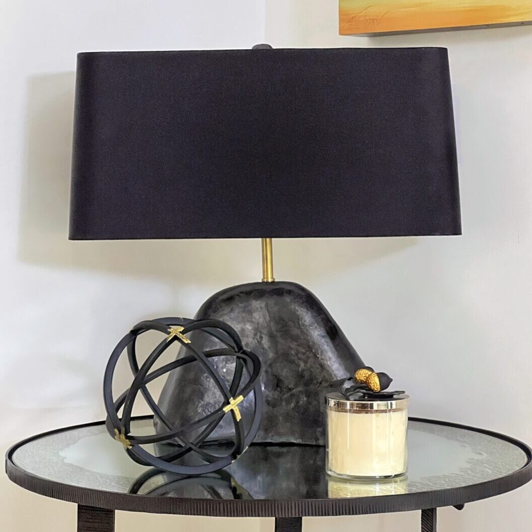 A table with a lamp and candle on it